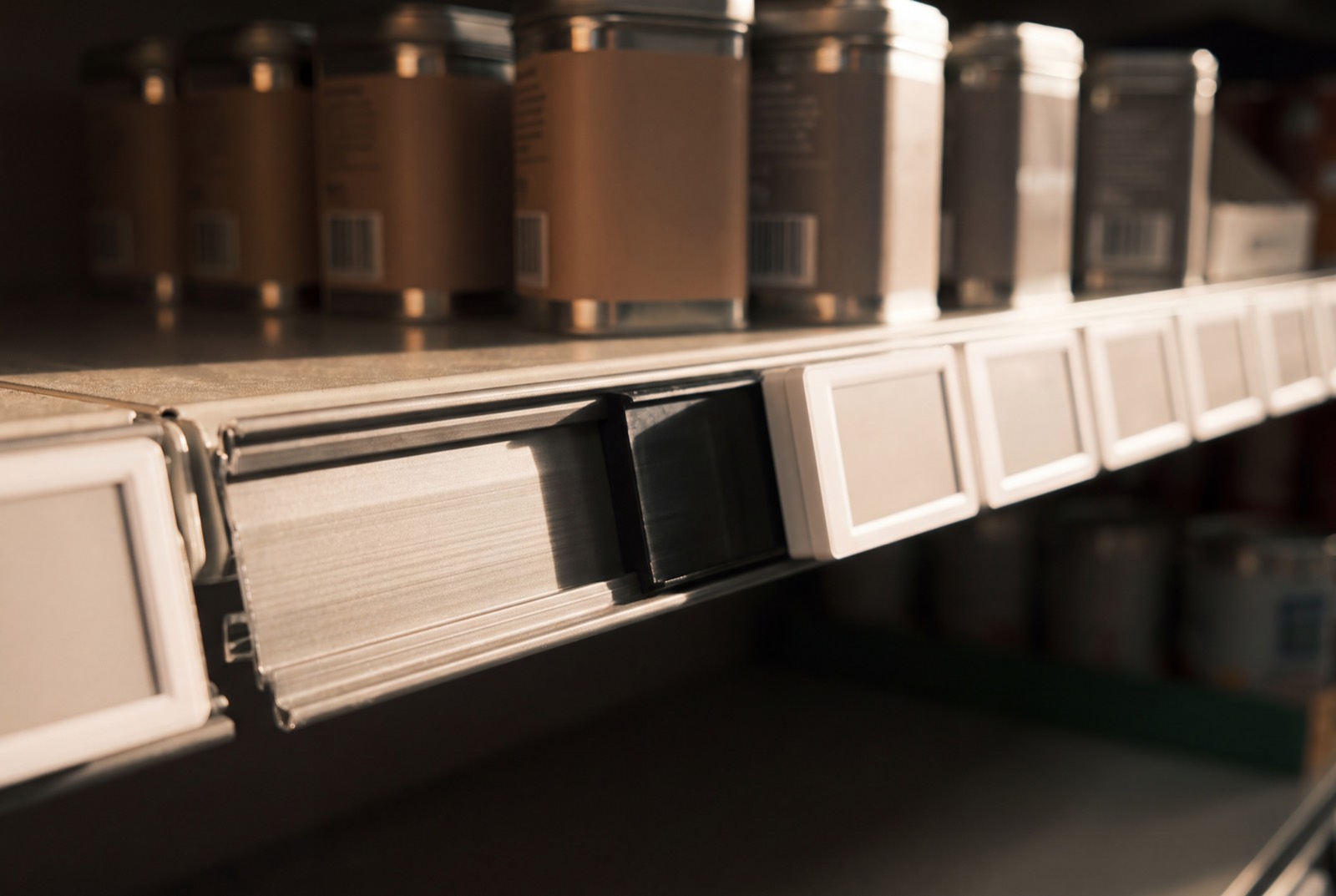 Close-up of an electronic shelf label mounted on a shelf-edge rail.